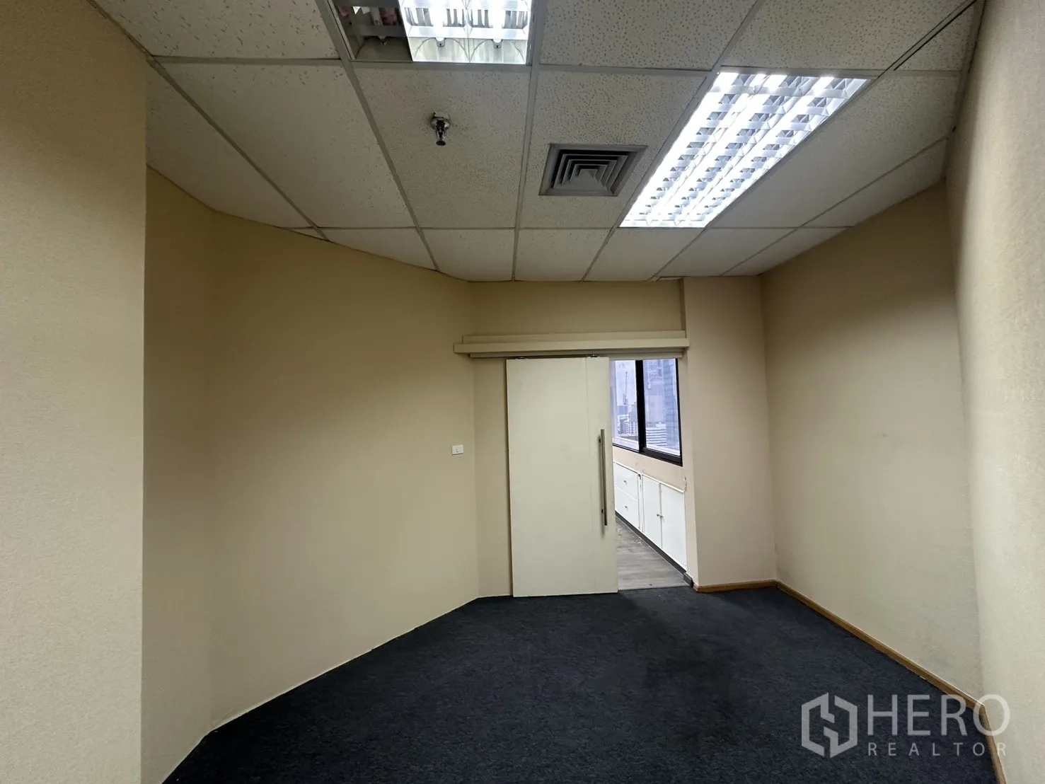 Office Space for rent in Bang Rak, Bangkok - Narrow carpeted office leading to the windowed main area.