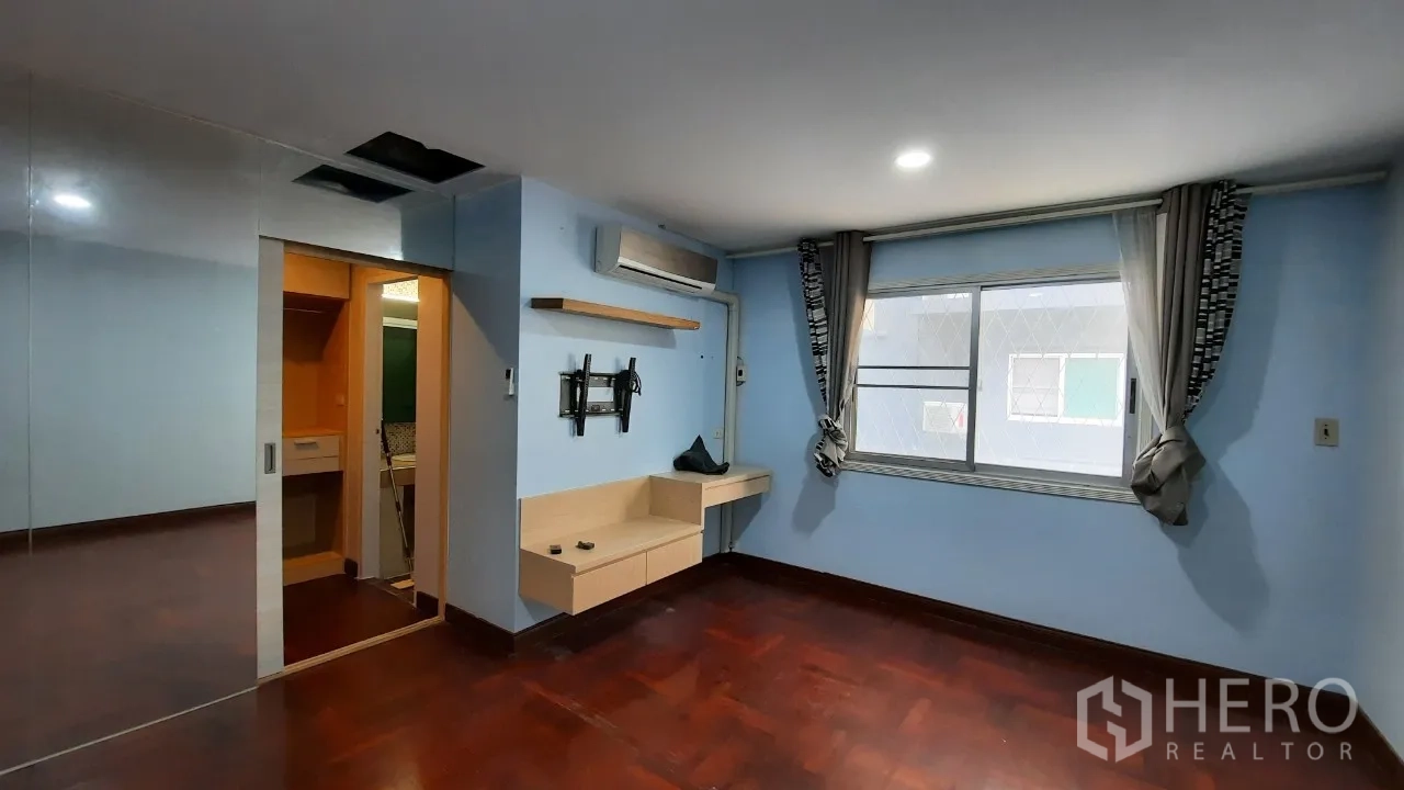 Townhouse for sale in Suan Luang, Bangkok - Blue-painted bedroom with air-conditioning and ensuite access