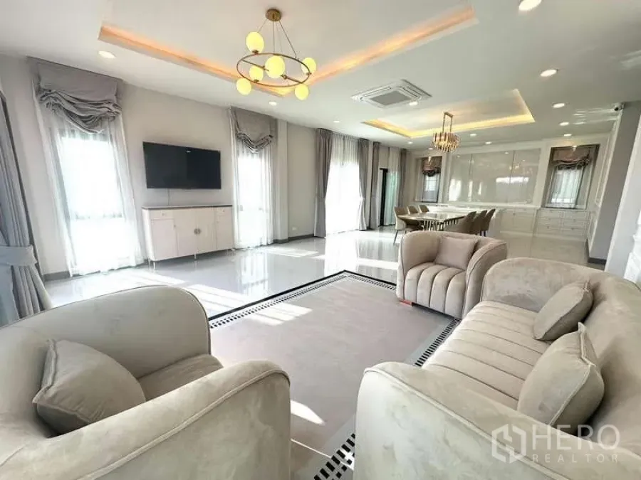 独立式住宅 出租在Bang Phli, Samut Prakan - 优雅客厅，米色沙发、壁挂电视与大窗