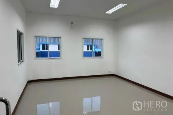 Warehouse for rent in Lam Luk Ka, Pathum Thani - Bright office room with windows and overhead lighting inside the warehouse.