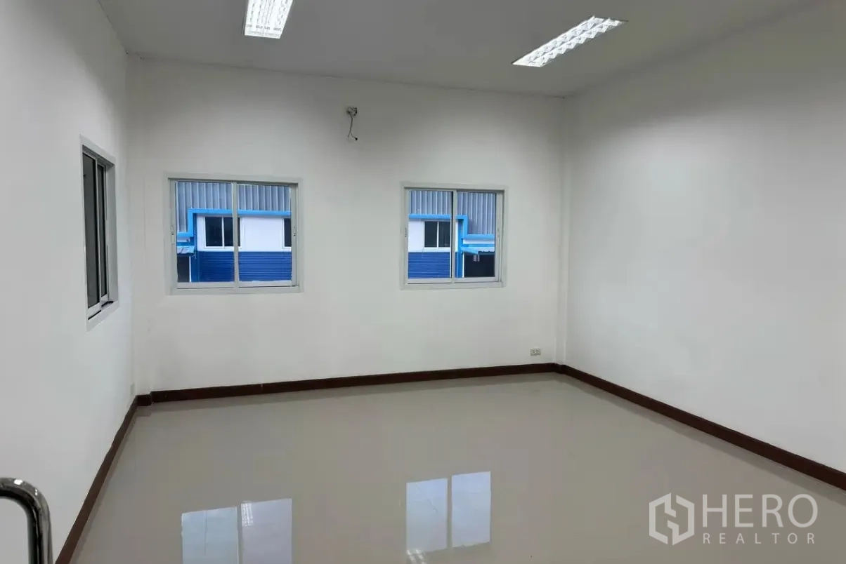 Warehouse for rent in Lam Luk Ka, Pathum Thani - Bright office room with windows and overhead lighting inside the warehouse.
