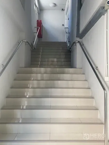 Office Space for rent in Bang Na, Bangkok - Glossy tiled staircase with stainless-steel handrails, side windows and a red fire hose cabinet.