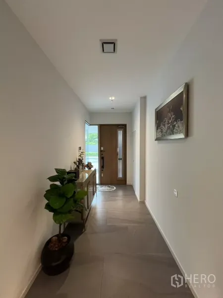 Detached House for rent in Saphan Sung, Bangkok - Bright entry corridor with large floor tiles, a wooden door and console table.
