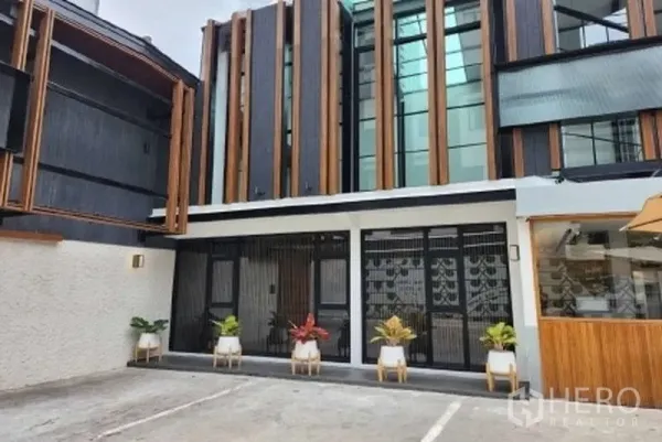 Retail Space for rent in Watthana, Bangkok - Street-facing retail facade with vertical wood details and potted plants.