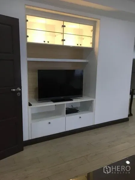 公寓 出租在Watthana, Bangkok - 客厅内嵌式电视墙，开放搁架与带灯玻璃柜