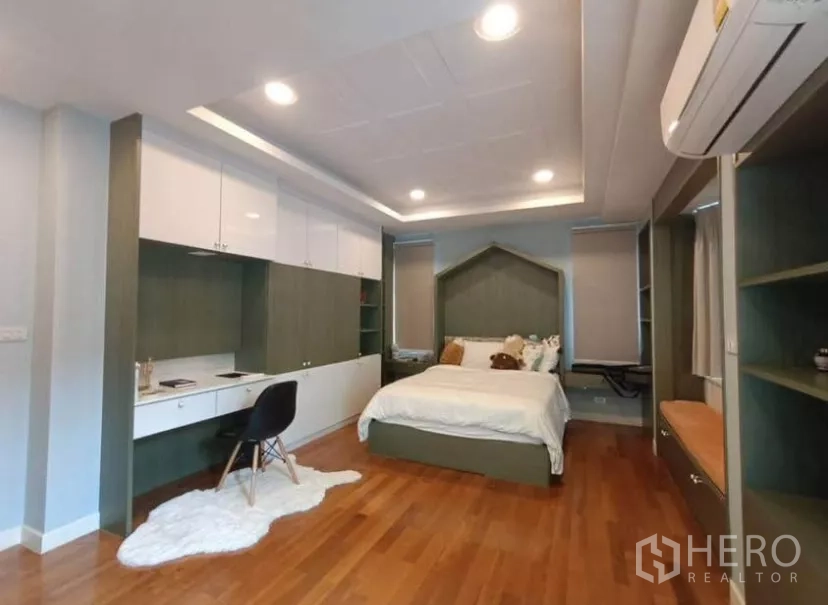 Townhouse for rent in Yan Nawa, Bangkok - Spacious bedroom with extensive built-ins, study area, and recessed lighting.