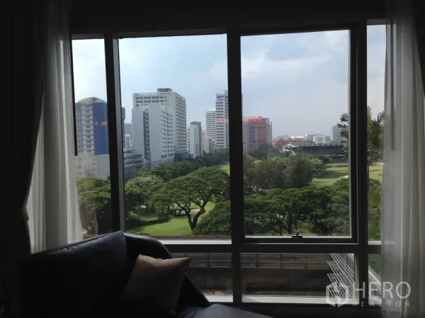 公寓 出租或出售在Pathum Wan, Bangkok - 客厅窗外的公园与曼谷天际线景观。