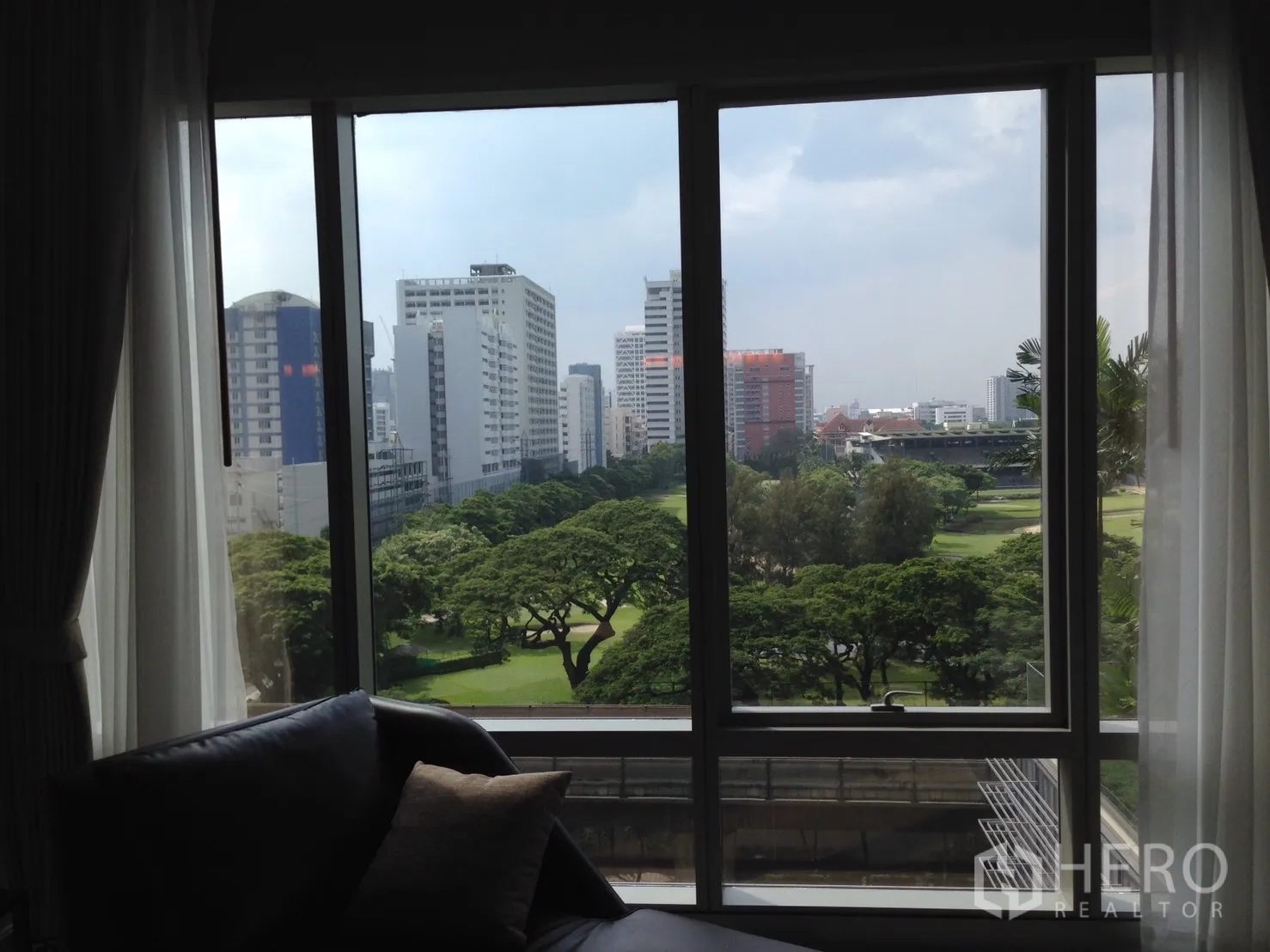 公寓 出租或出售在Pathum Wan, Bangkok - 客厅窗外的公园与曼谷天际线景观。
