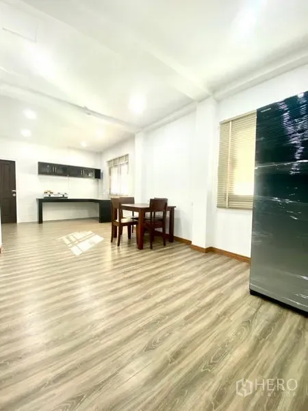 Townhouse for rent in Prawet, Bangkok - Dining nook beside large windows and a modern pantry with cabinets and fridge.