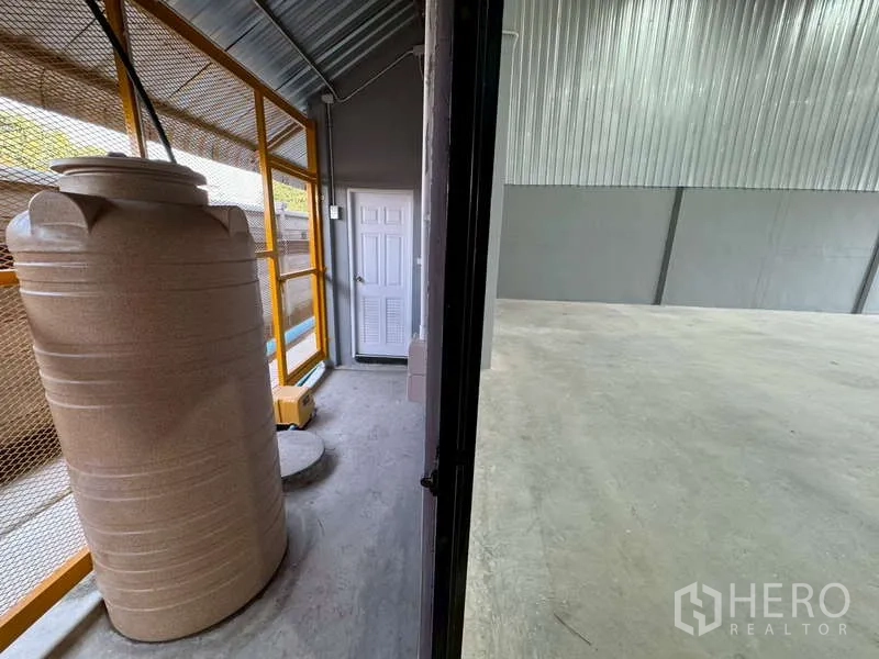 Warehouse for rent in Bang Phli, Samut Prakan - Transition from the service area into the open concrete-floored warehouse