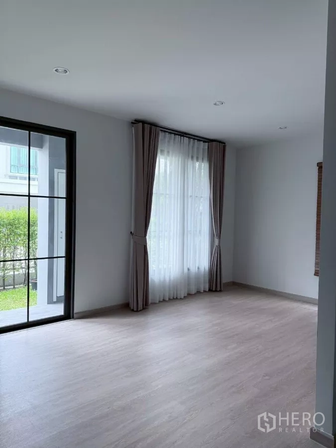 Detached House for rent in Lat Krabang, Bangkok - Ground-floor flex room opening to garden via sliding glass door and windows.