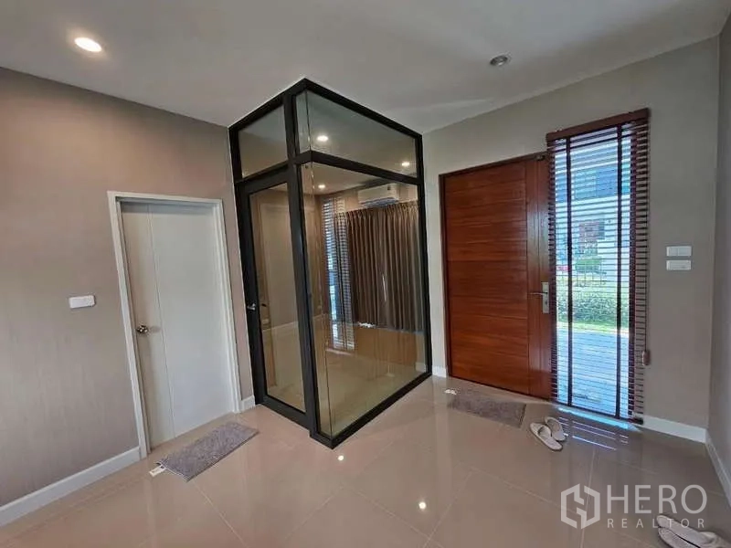 Detached House for rent in Bang Phli, Samut Prakan - Entrance hall featuring a glass-enclosed multipurpose room and a wooden front door.