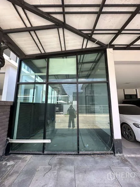Detached House for sale in Lam Luk Ka, Pathum Thani - Glass-enclosed multipurpose room beside the covered carport.