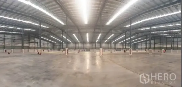 โรงงาน ให้เช่าในMueang Rayong, Rayong - มุมพาโนรามาของพื้นโกดังขนาดกว้าง พร้อมไฟเส้นสว่างและเสาโครงสร้างเหล็กเรียงตัว