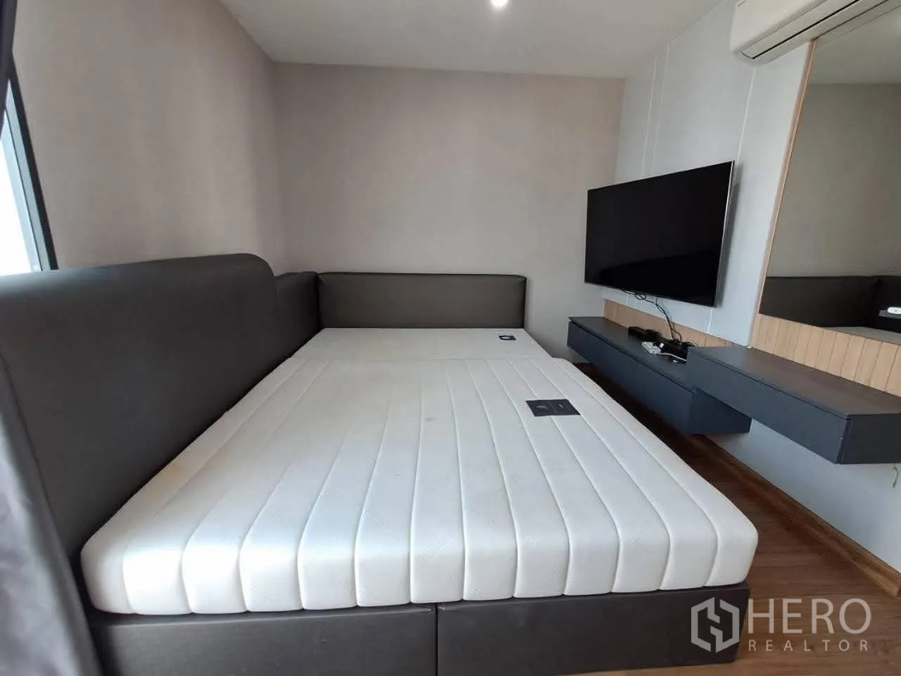 Townhouse for rent in Bang Kapi, Bangkok - Bedroom with large bed, wall-mounted TV and air conditioning.