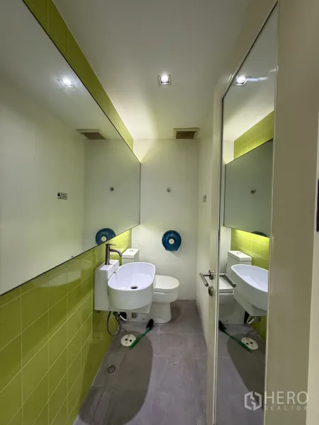 Retail Space for rent in Bang Rak, Bangkok - Private restroom with green accent tiles, long wall mirror and white sanitary ware.