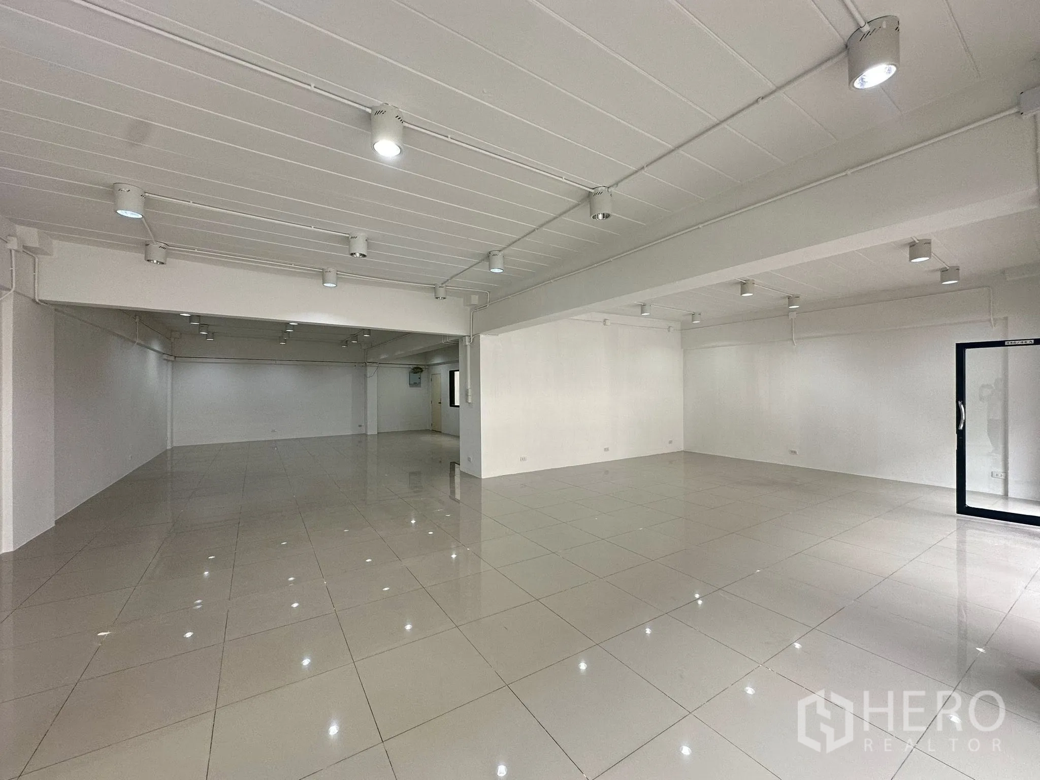 办公空间 出租在Watthana, Bangkok - 全景开放式楼层，右侧为玻璃门，LED灯明亮。