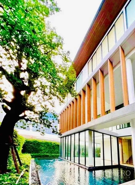 独立式住宅 出售在Huai Khwang, Bangkok - 现代外立面配竖向木格栅，泳池与成树相映成趣。