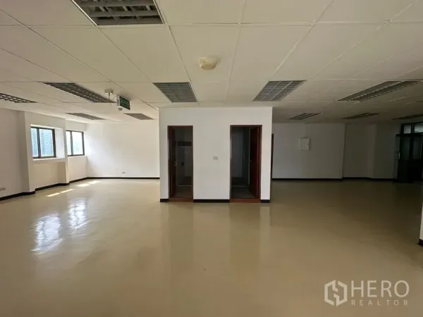 Office Space for rent in Pathum Wan, Bangkok - Spacious open-plan office with drop ceiling, fluorescent lighting, two internal rooms and light-colored flooring.