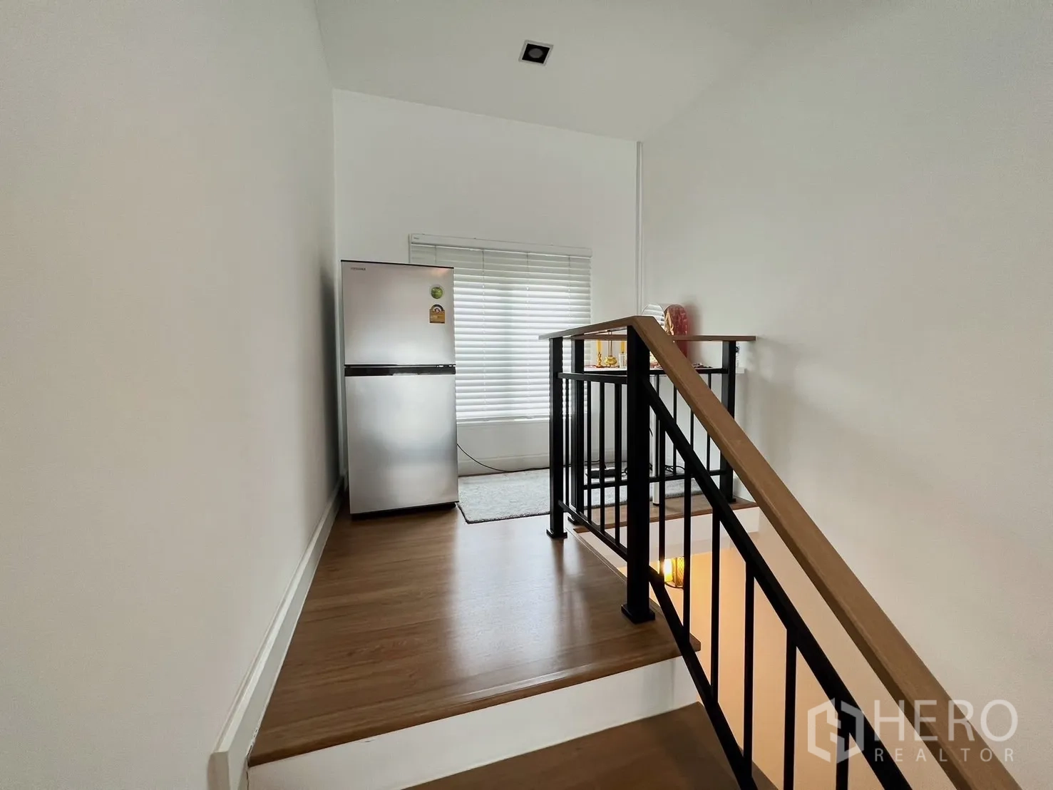 Detached House for rent or sale in Khlong Luang, Pathum Thani - Stair landing with metal handrail, window and freestanding refrigerator.