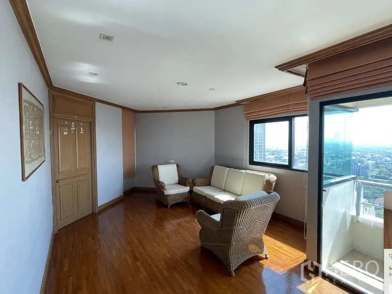 Condominium for rent - Cozy sitting nook with wicker chairs next to balcony and city views.