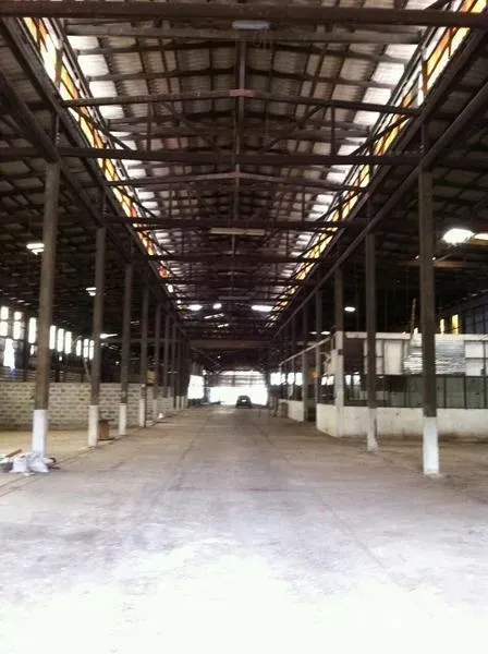 Factory for rent in Khlong San, Bangkok - Long central aisle under a steel truss roof with multiple columns in the warehouse hall.