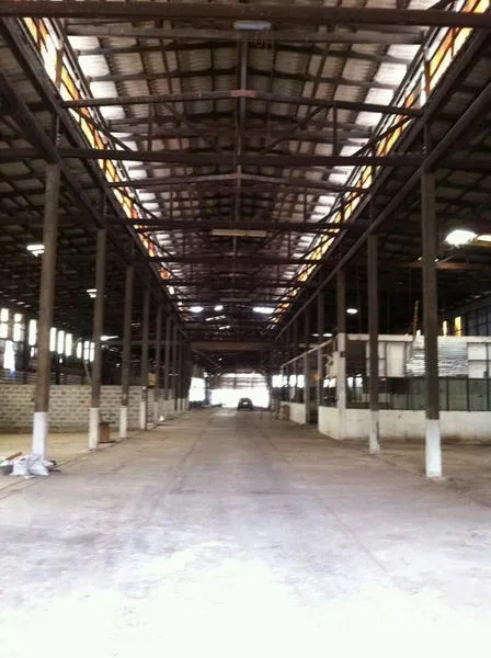 Factory for rent in Khlong San, Bangkok - Long central aisle under a steel truss roof with multiple columns in the warehouse hall.