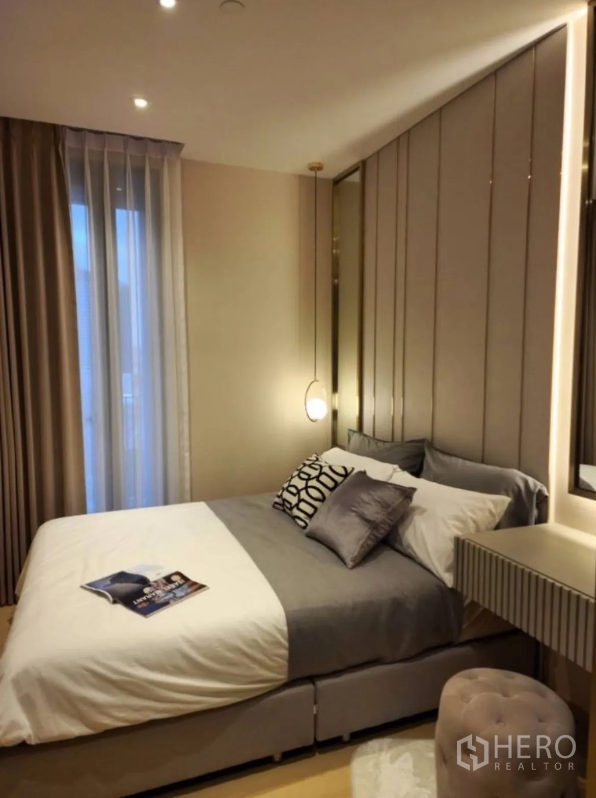 Condominium for rent in Din Daeng, Bangkok - Warm bedroom featuring an upholstered headboard and pendant bedside light.