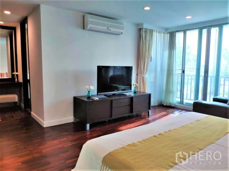 公寓 出租在Bang Rak, Bangkok - 主卧另一角度，可见电视柜、空调与阳台推拉门。