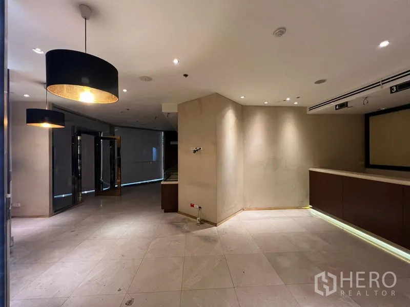 Retail Space for rent - Lobby-style retail area showing pendant lamps, tiled flooring, and under-counter lighting.