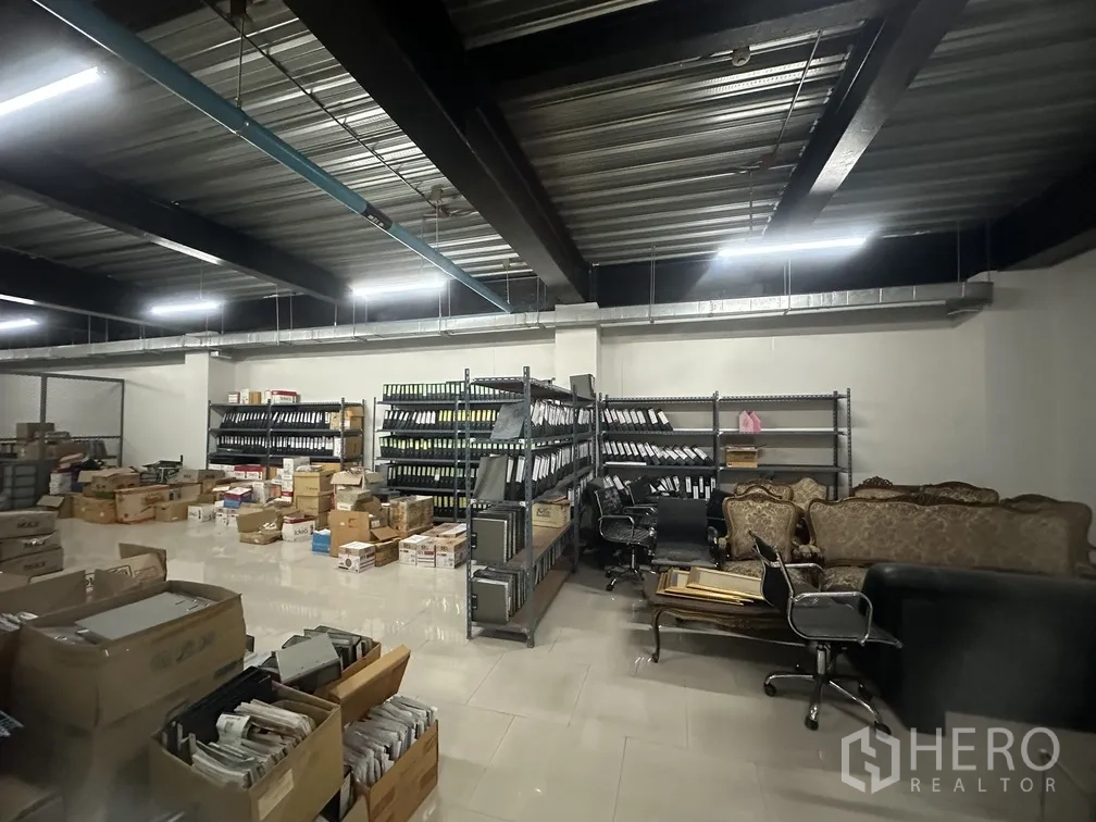 工厂 for rent in Lam Luk Ka, Pathum Thani - 宽敞储物区，货架、纸箱与休闲沙发。