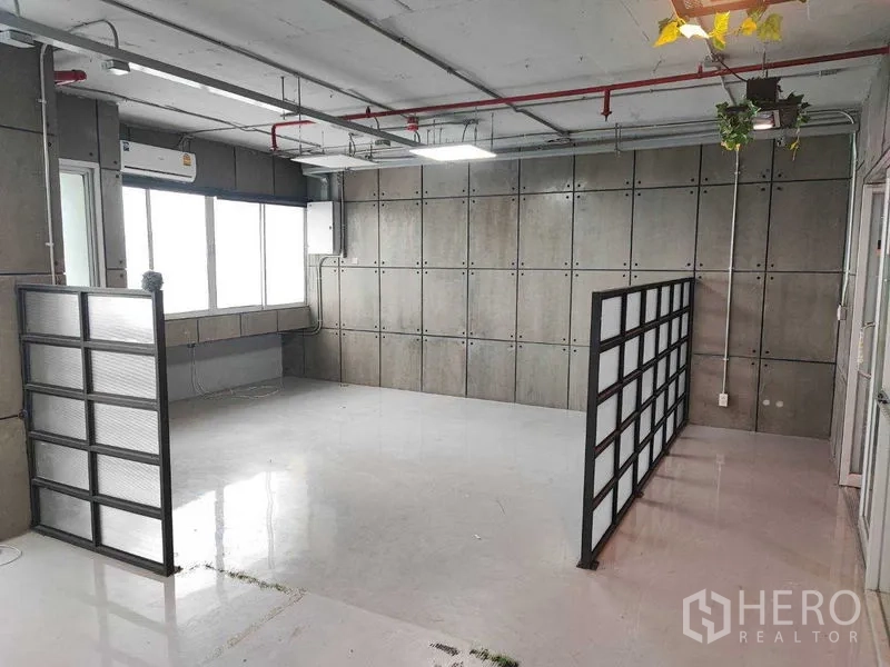 办公空间 出租在Watthana, Bangkok - 开放空间，黑框隔断两组，外露管线及吊挂绿植。