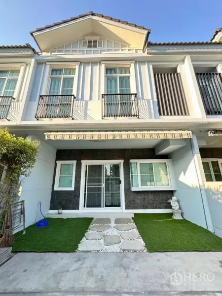 Townhouse for rent in Bang Phli, Samut Prakan - Front facade of the Indy 4 Bangna Km.7 townhouse with a small lawn and stone path.