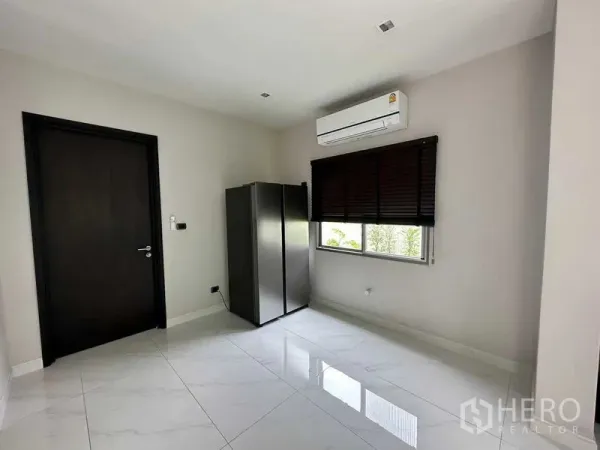 Detached House for rent in Lat Krabang, Bangkok - Bright unfurnished room with glossy white tile floors, window blinds and a wall air conditioner.