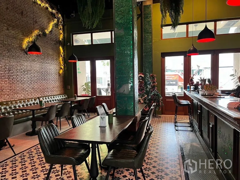 Shophouse for rent in Watthana, Bangkok - Restaurant-style dining area with bar counter, pendant lights, brick feature wall, and patterned floor tiles.