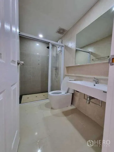 联排别墅 出租在Wang Thonglang, Bangkok - 浴室设长台盆、坐便与玻璃淋浴间。