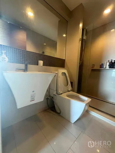 Condominium for sale in Phaya Thai, Bangkok - Bright guest bathroom with wall‑mounted sink, toilet, and walk‑in shower.