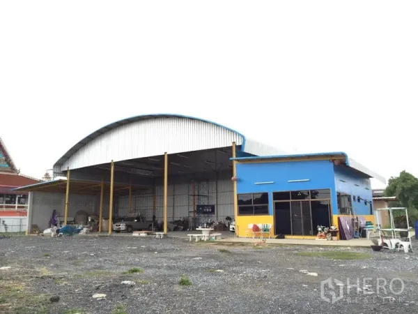 货栈 出租在Mueang Pathum Thani, Pathum Thani - 钢结构仓库正面，高拱形屋顶，旁侧带玻璃立面的办公室。