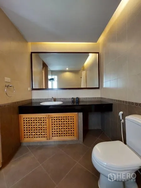 Apartment for rent - Second bathroom with large mirror, modern lighting, vanity and toilet.