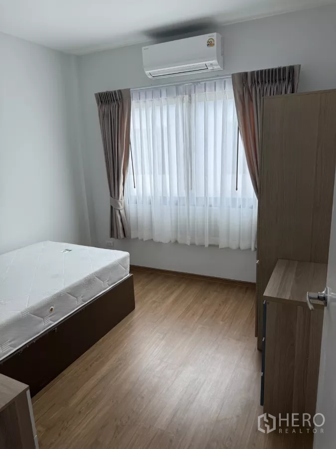 Townhouse for rent or sale in Bang Phli, Samut Prakan - Bright bedroom with bed, air-conditioner and natural light.