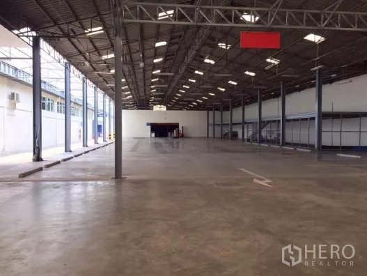 Warehouse for rent in Khlong Luang, Pathum Thani - Deep warehouse aisle with multiple columns, bright lighting and loading area.