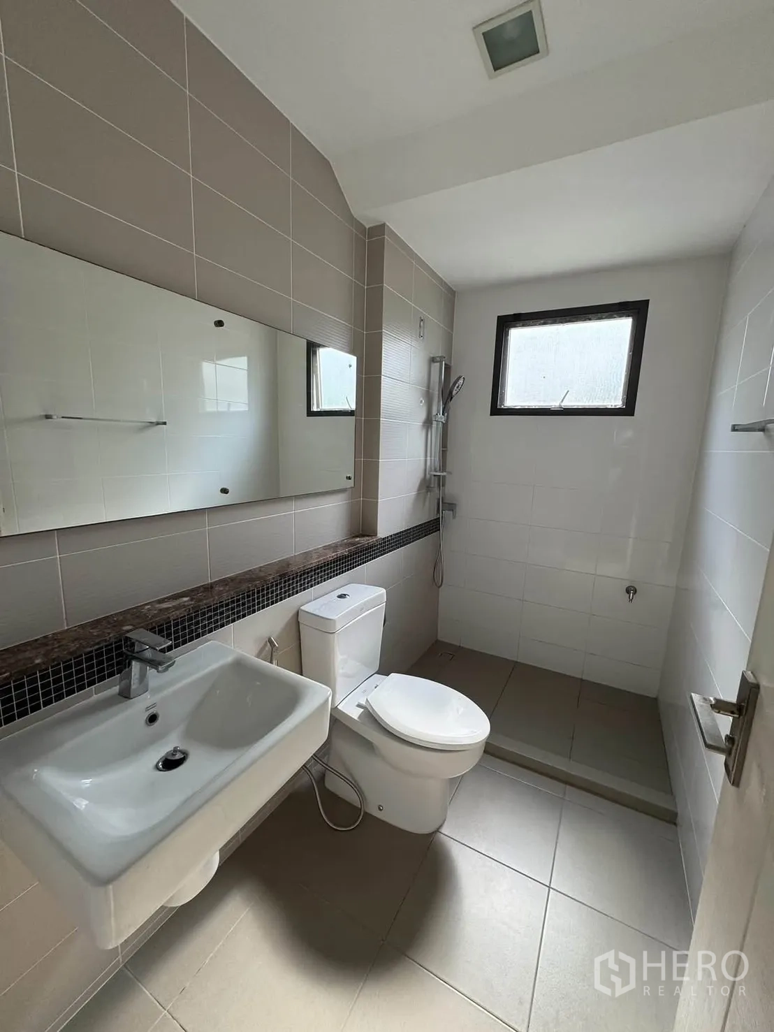 Detached House for rent in Prawet, Bangkok - Bathroom with a sink, toilet, walk-in shower, and a wide mirror.