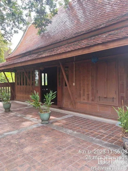 บ้าน ให้เช่าหรือขายในSuan Luang, Bangkok - บ้านไม้ไทยยกพื้น พร้อมชานปูกระเบื้องอิฐกว้างและกระถางต้นไม้.