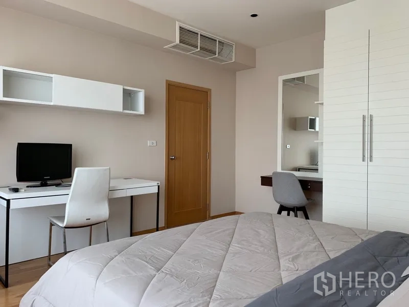Condominium for rent in Khlong Toei, Bangkok - Bedroom corner featuring a work desk, door and built-in storage.