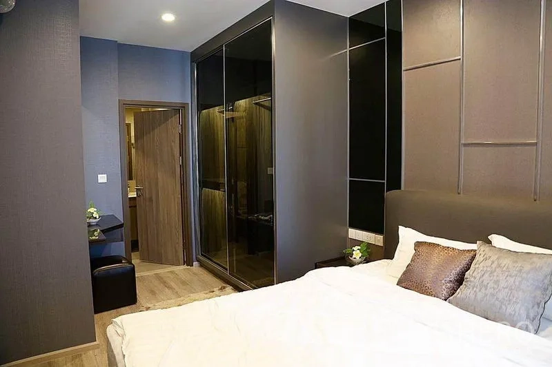 公寓 出租在Huai Khwang, Bangkok - 公寓卧室一角，内置镜面衣柜与浴室入口。