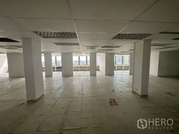 办公空间 出租在Khlong Toei, Bangkok - 开放式办公楼层，带立柱、吊顶与整排窗户，可眺望曼谷天际线。