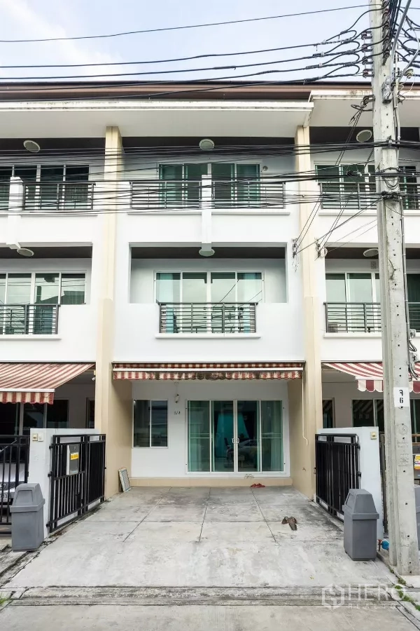 Townhouse for rent - Three-storey townhouse facade with gated driveway for two cars and sliding glass door