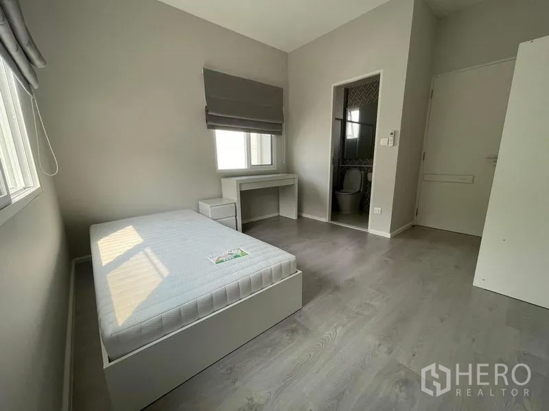 Detached House for rent in Prawet, Bangkok - Cozy ensuite bedroom with bed, study desk and private bathroom entrance.