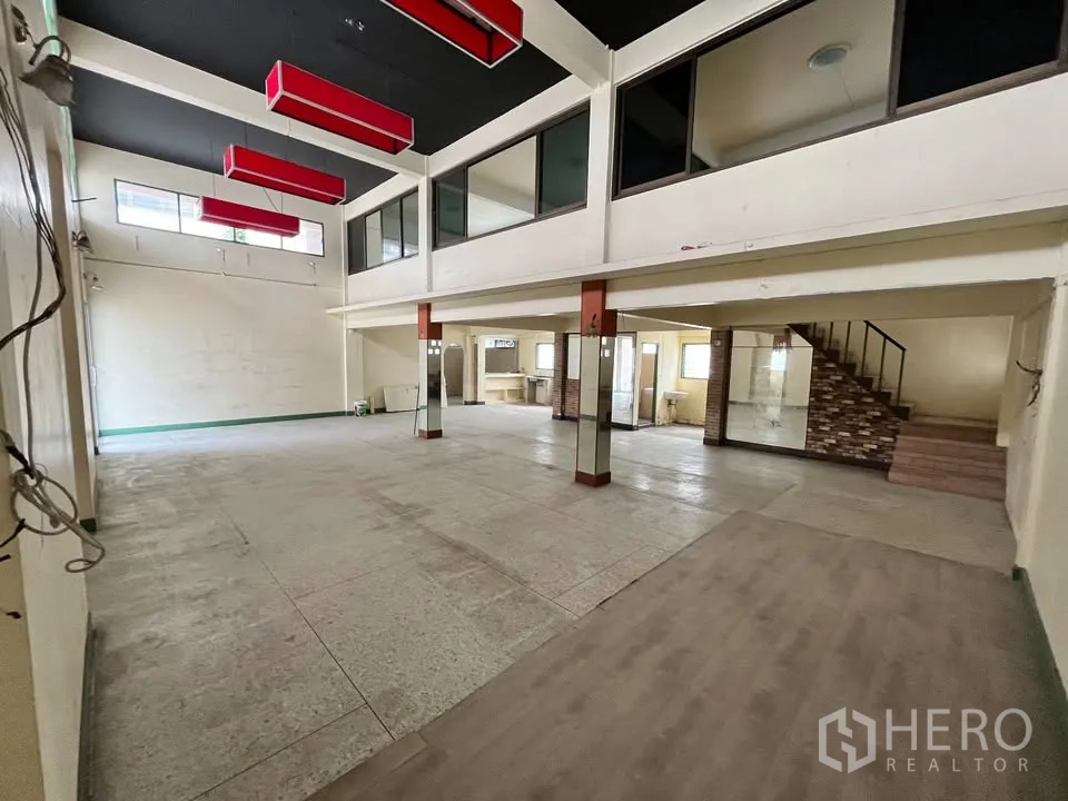 Detached House for rent in Suan Luang, Bangkok - Large open hall with staircase, mezzanine, and red ceiling fixtures.