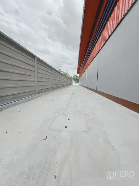货栈 出租或出售在Khlong Luang, Pathum Thani - 仓库侧边服务通道，混凝土路面与边界围墙。